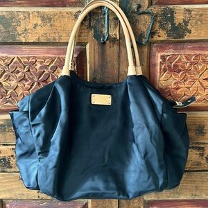 Black Kate Spade maternity diaper bag with diaper pad and interior pockets.